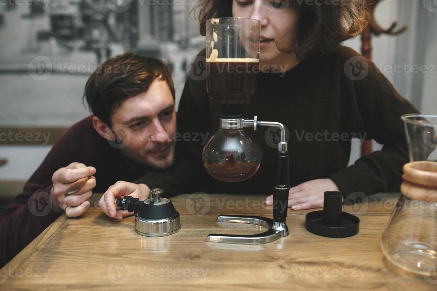 årgång par framställning kaffe med Vakuum kaffe maker.kaffe affär foto