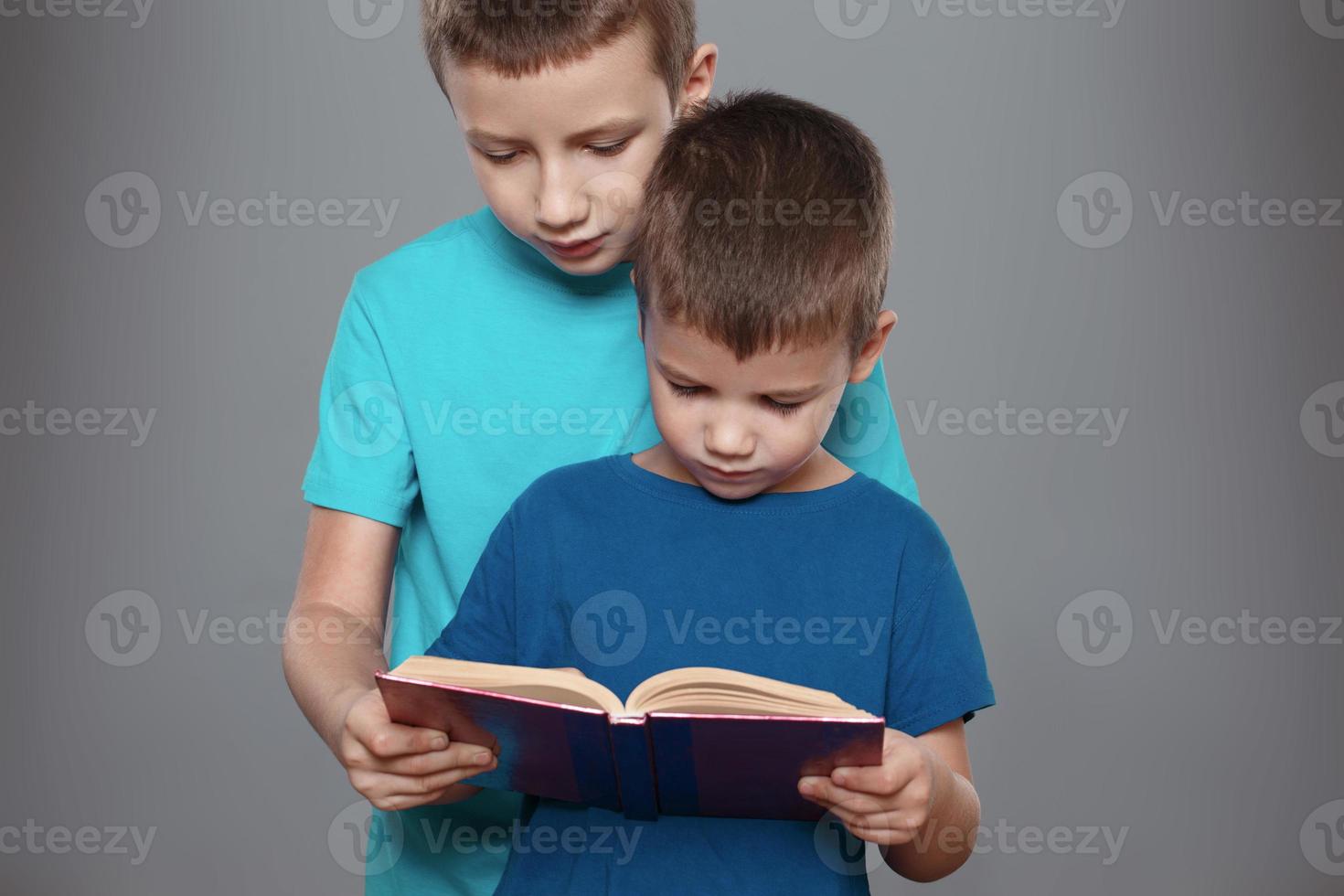 små pojkar som läser intressant bok foto