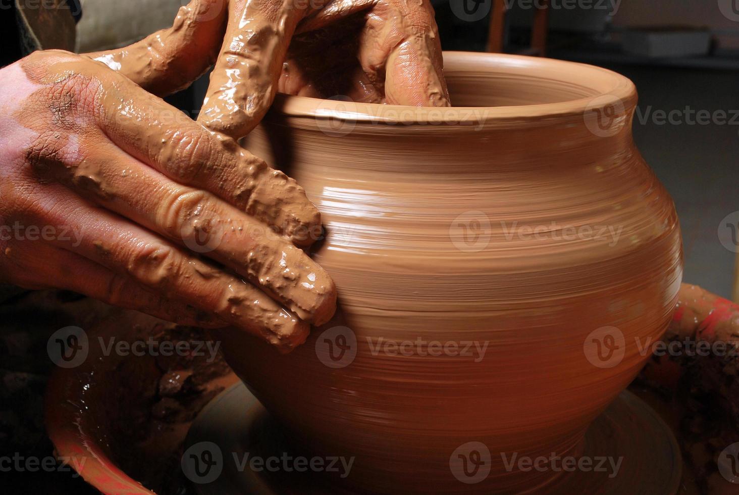 händerna på en keramiker som skapar en lerkrukan foto