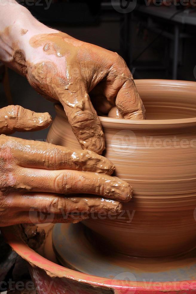 man gör keramik på det snurrande keramikhjulet foto
