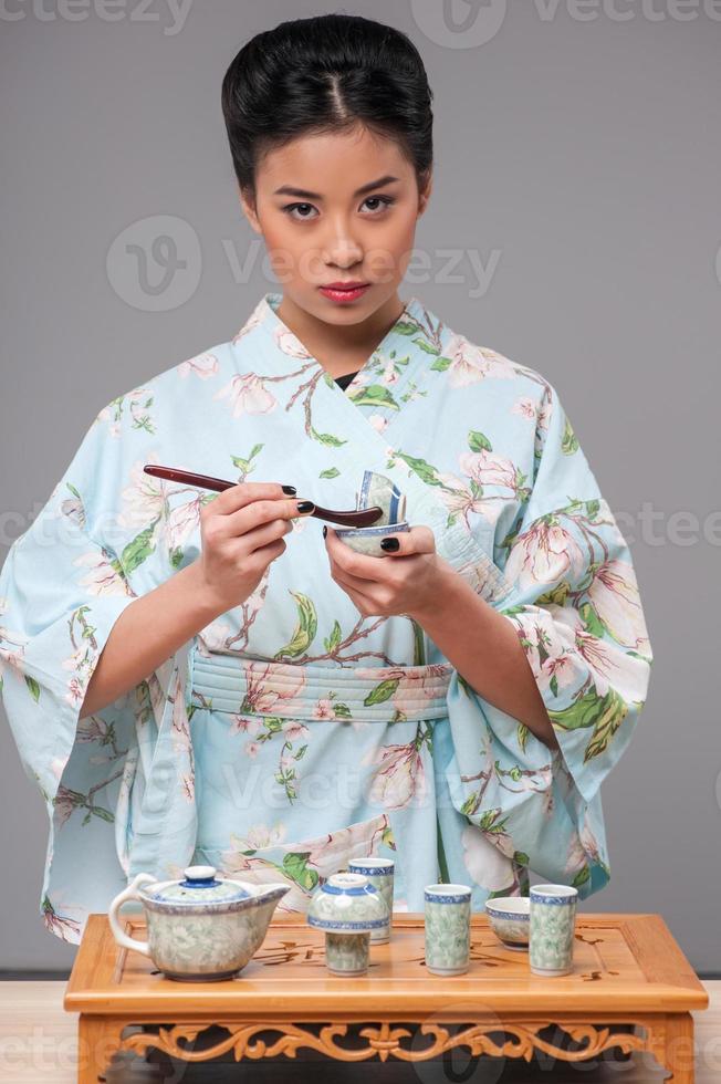 japansk kvinna som förbereder teceremoni foto