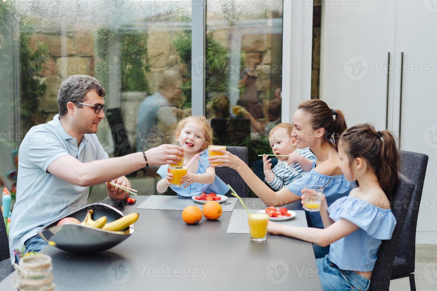 Lycklig familj äter färsk frukt frukost foto