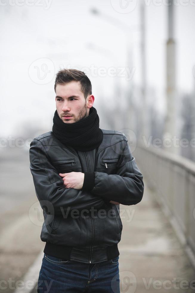 en man klädd i jeans och jacka står nära de huvud väg i dimmig väder foto
