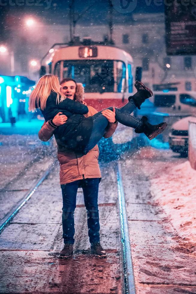 ung vuxen par på de snötäckt spårvagn linje foto