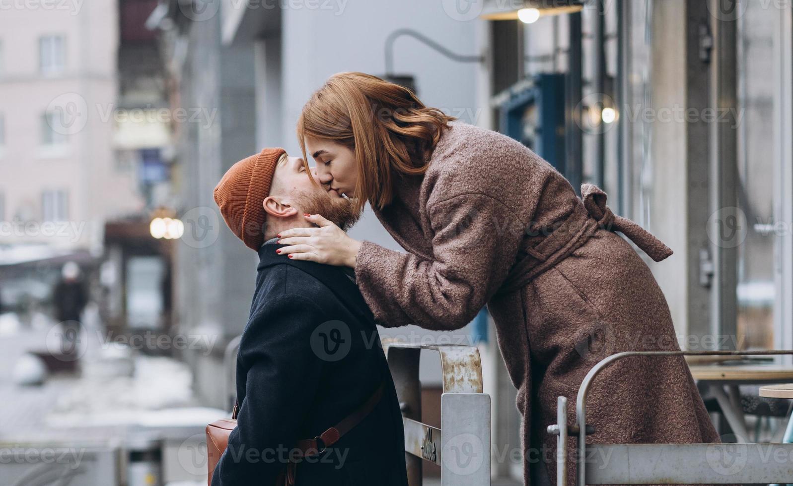 vuxen kärleksfull par kissing på en gata foto