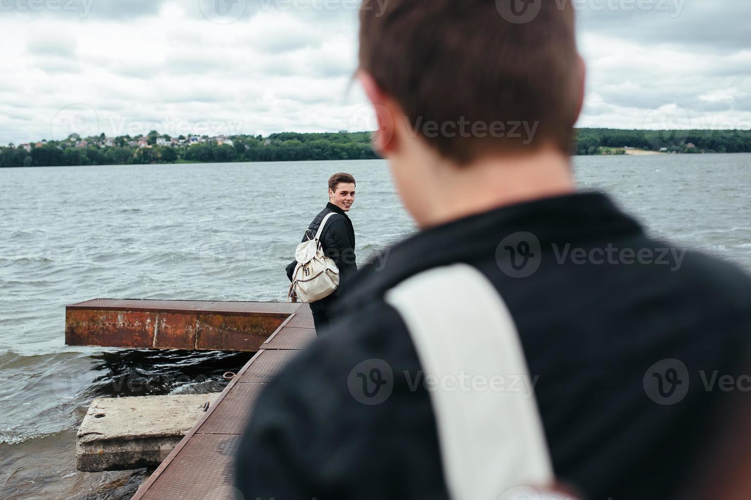 två unga killar som står på en pir foto