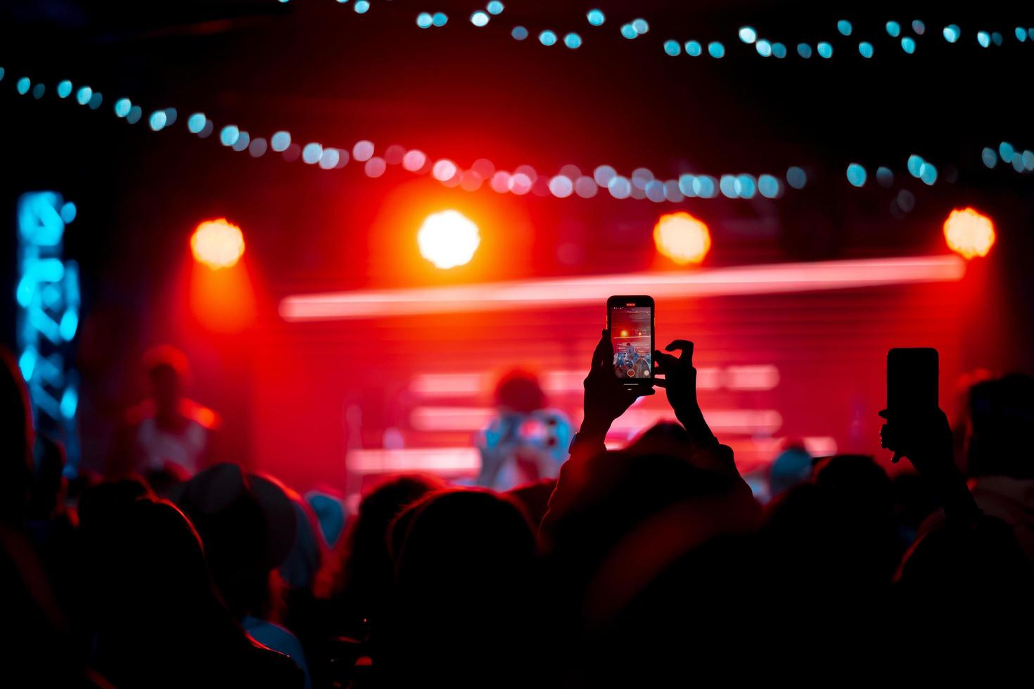 person stänga upp av inspelning video med smartphone under en konsert. foto