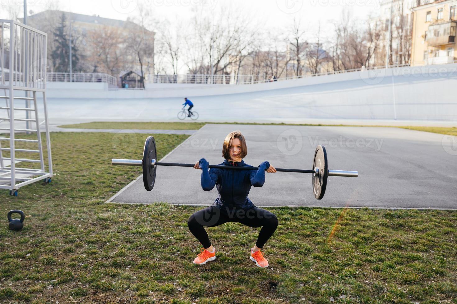 stark kvinna utövar med skivstång. sporter, kondition begrepp. foto