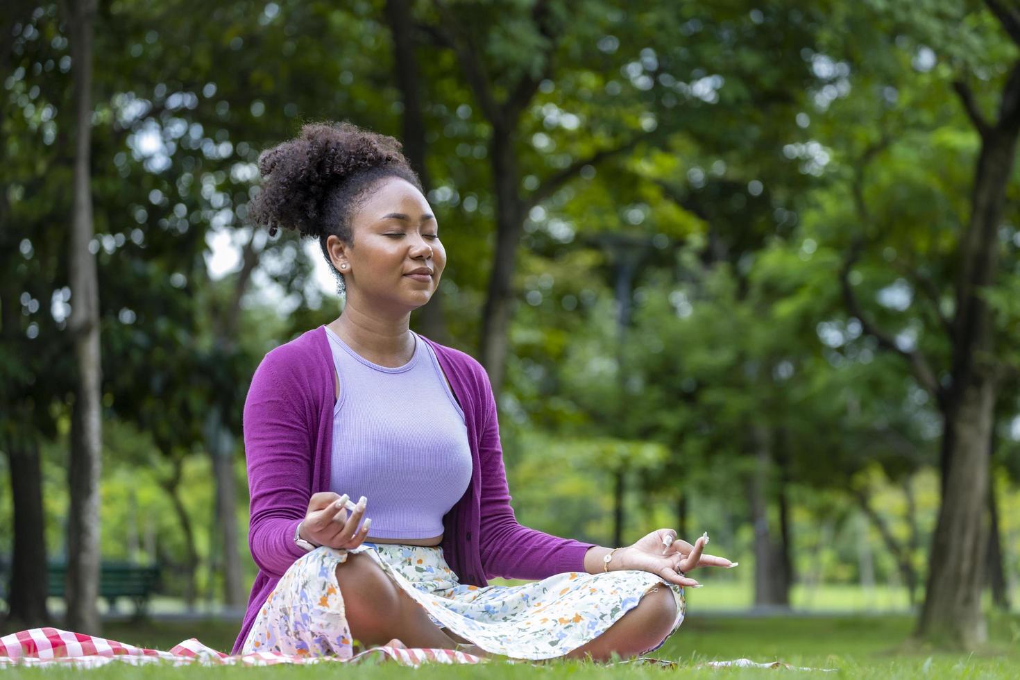 afrikansk amerikan kvinna avkopplande praktiserande meditation i de skog till uppnå lycka från inre fred visdom för friska sinne och själ begrepp foto