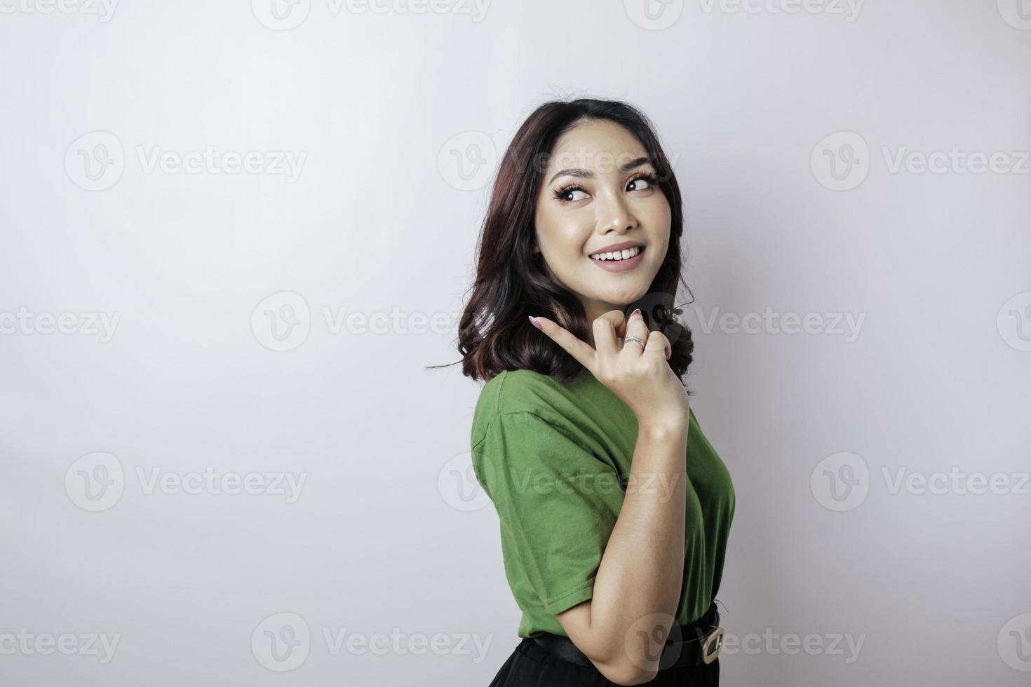 leende skön asiatisk kvinna pekande finger åt sidan till tömma Plats isolerat vit bakgrund foto