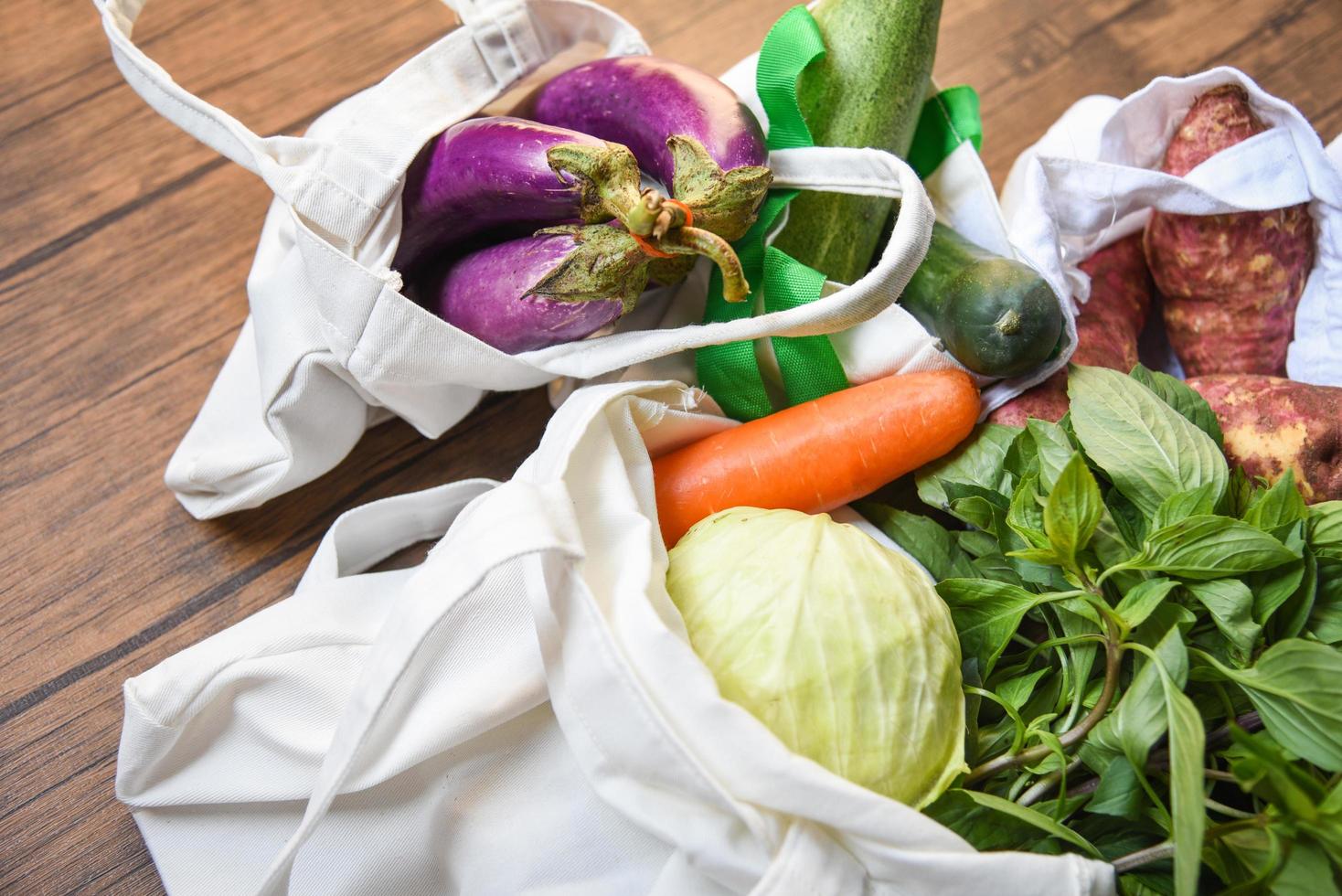 noll avfall använd mindre plastkoncept färska grönsaker ekologiska i ekologiska bomullstygpåsar på träbord foto