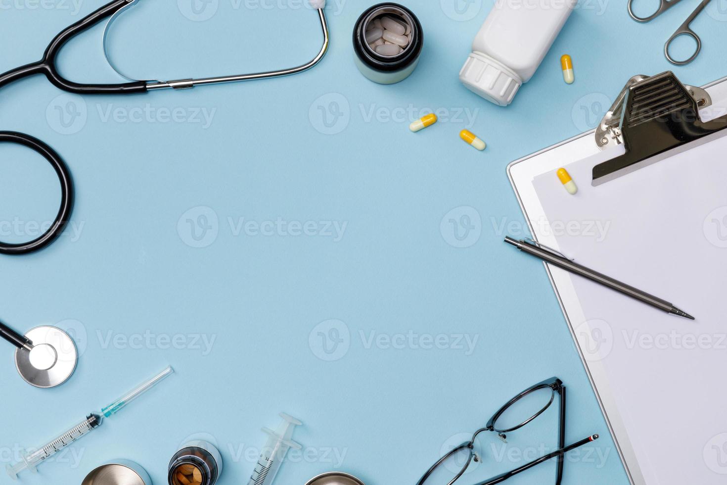 kreativ flatlay av läkare medicinsk Utrustning blå tabell med stetoskop, medicinsk dokument, termometer, spruta och biljard, hälsa vård begrepp, topp se med kopia Plats, isolerat på blå foto