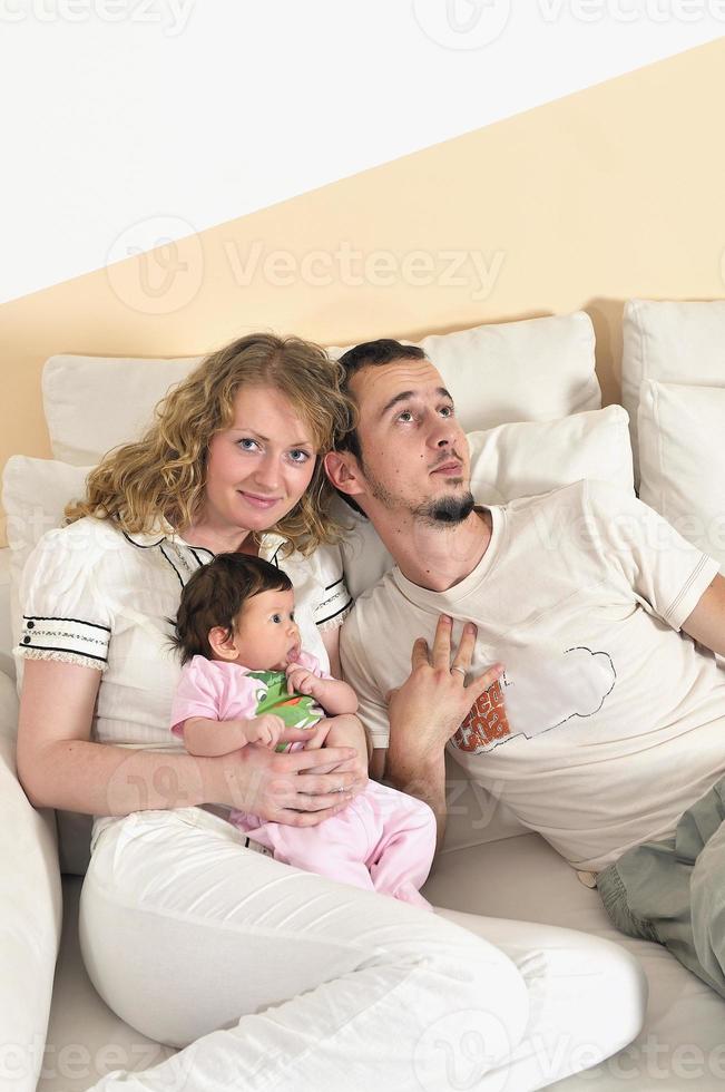 inomhus- porträtt med Lycklig ung familj och söt liten älskling foto