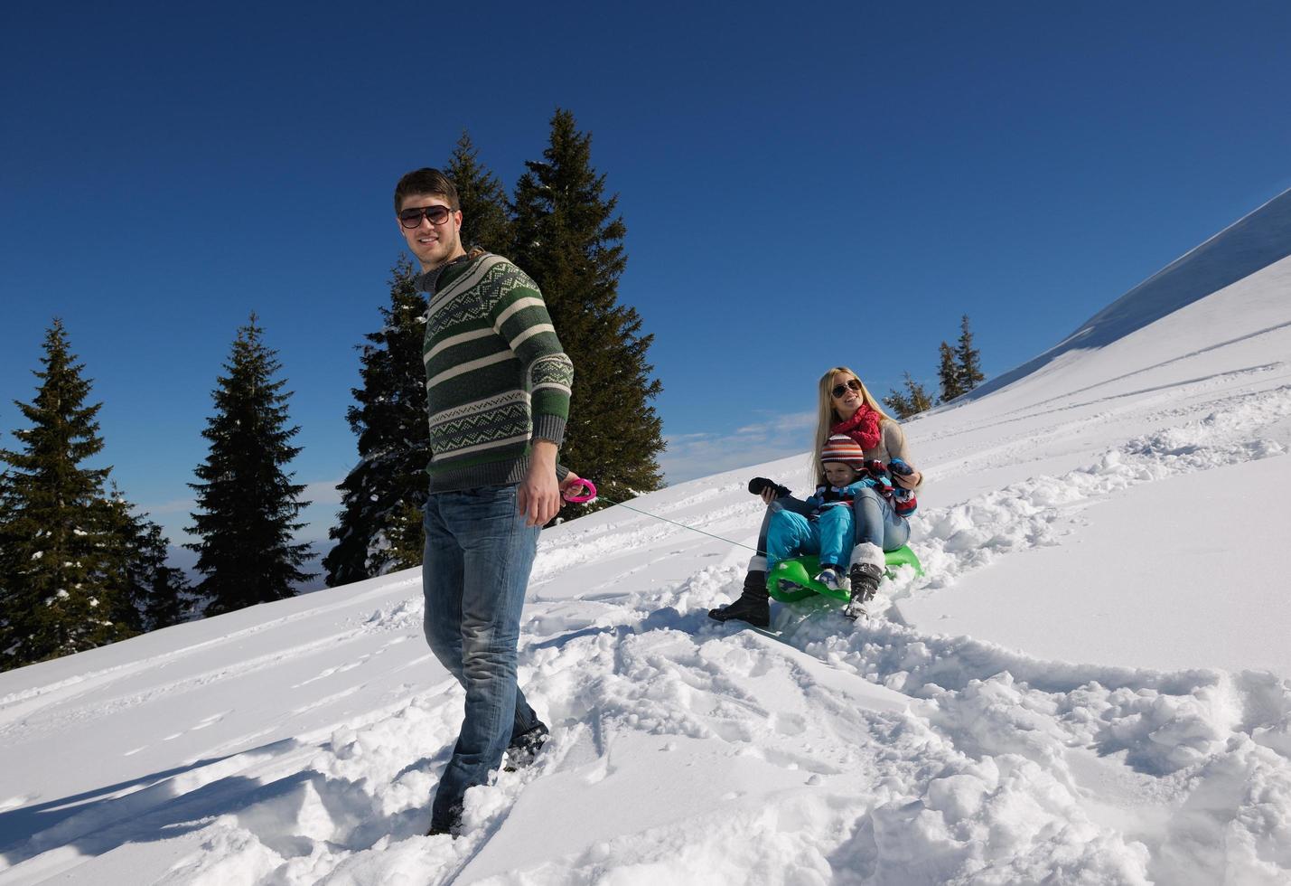 familj har roligt på färsk snö på vinter- semester foto