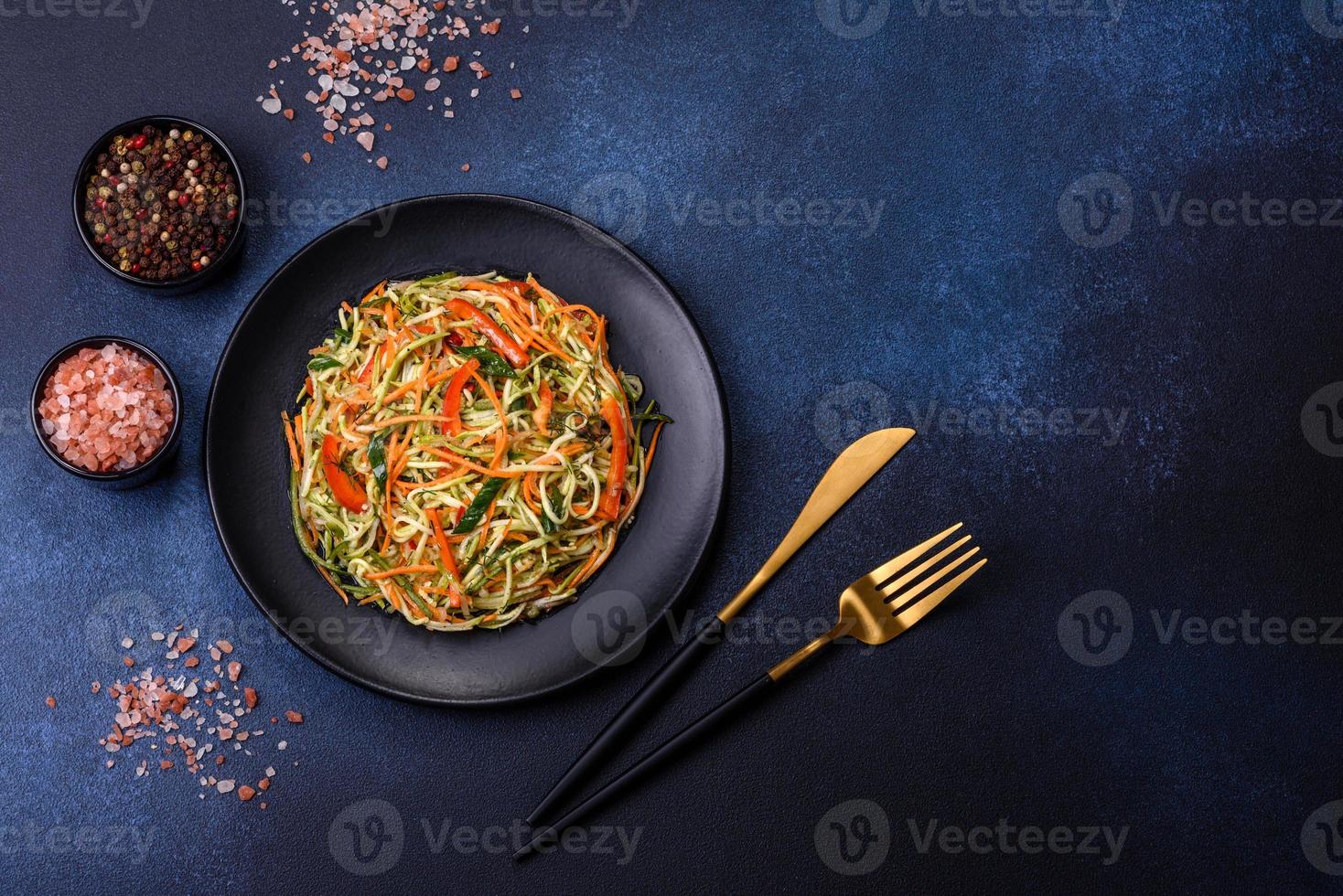 färsk sallad av skivad tunn remsor av morot och zucchini på en betong bakgrund foto