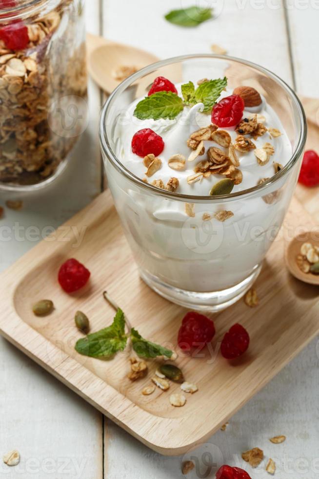 grekisk yoghurt i en glas med skedar på trä- bakgrund foto