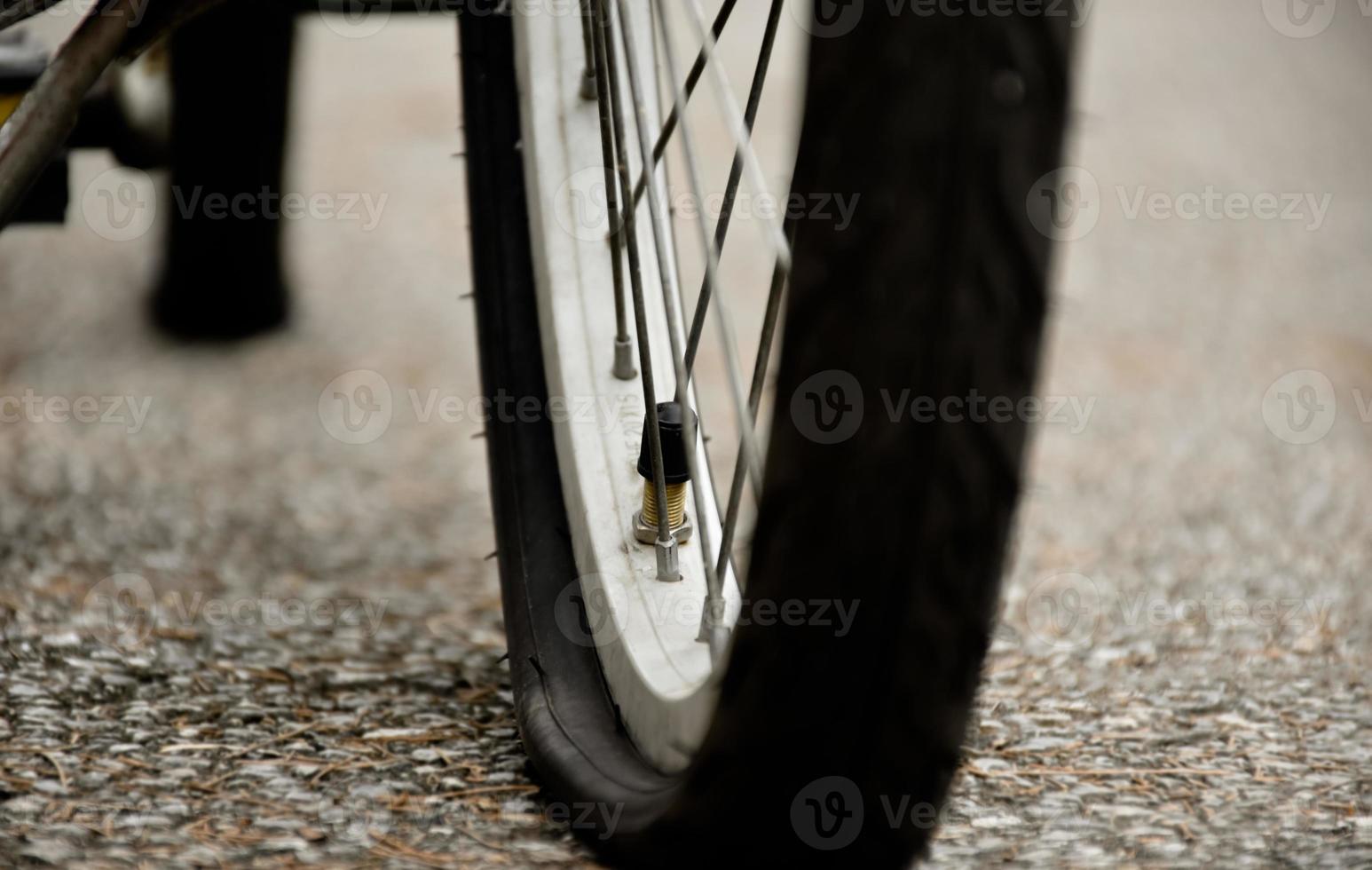 närbild se av bak- platt däck av årgång cykel som parkerad på trottoar bredvid de väg. mjuk och selektiv fokus. foto
