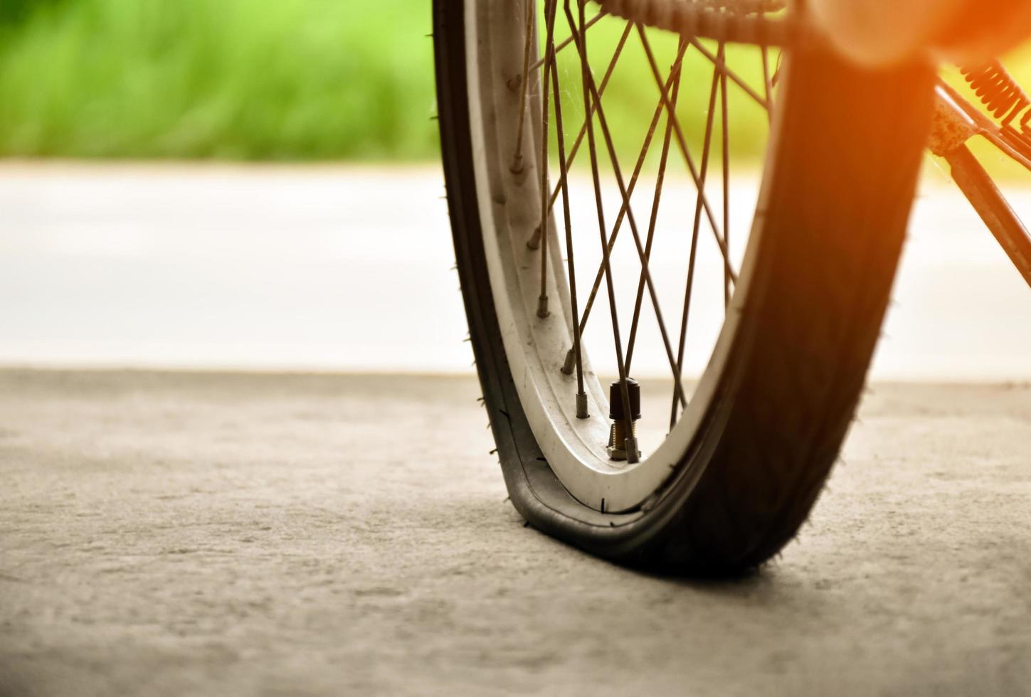 bak- hjul av cykel som är platt och parkerad på de trottoar bredvid de väg. foto