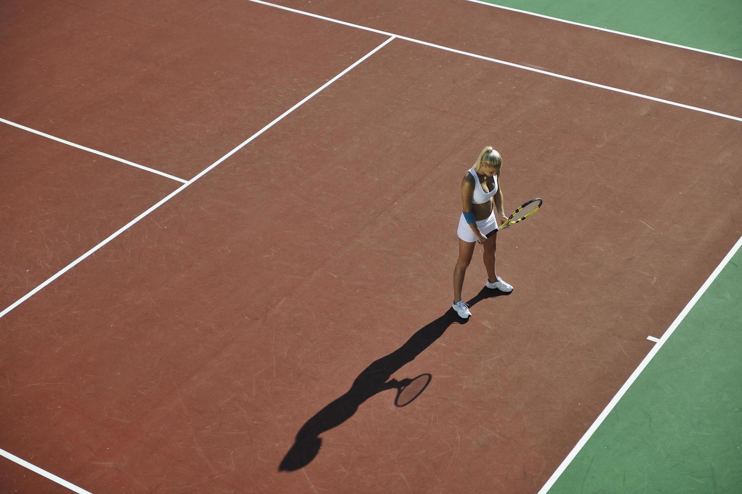 ung kvinna spela tennis utomhus foto