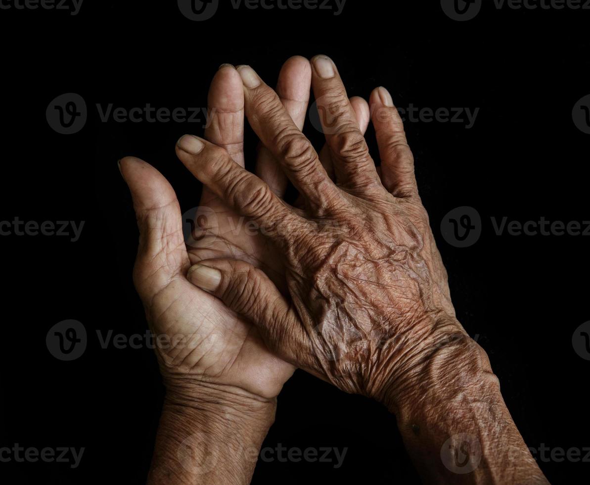 de gammal händer mormor i en svart bakgrund foto