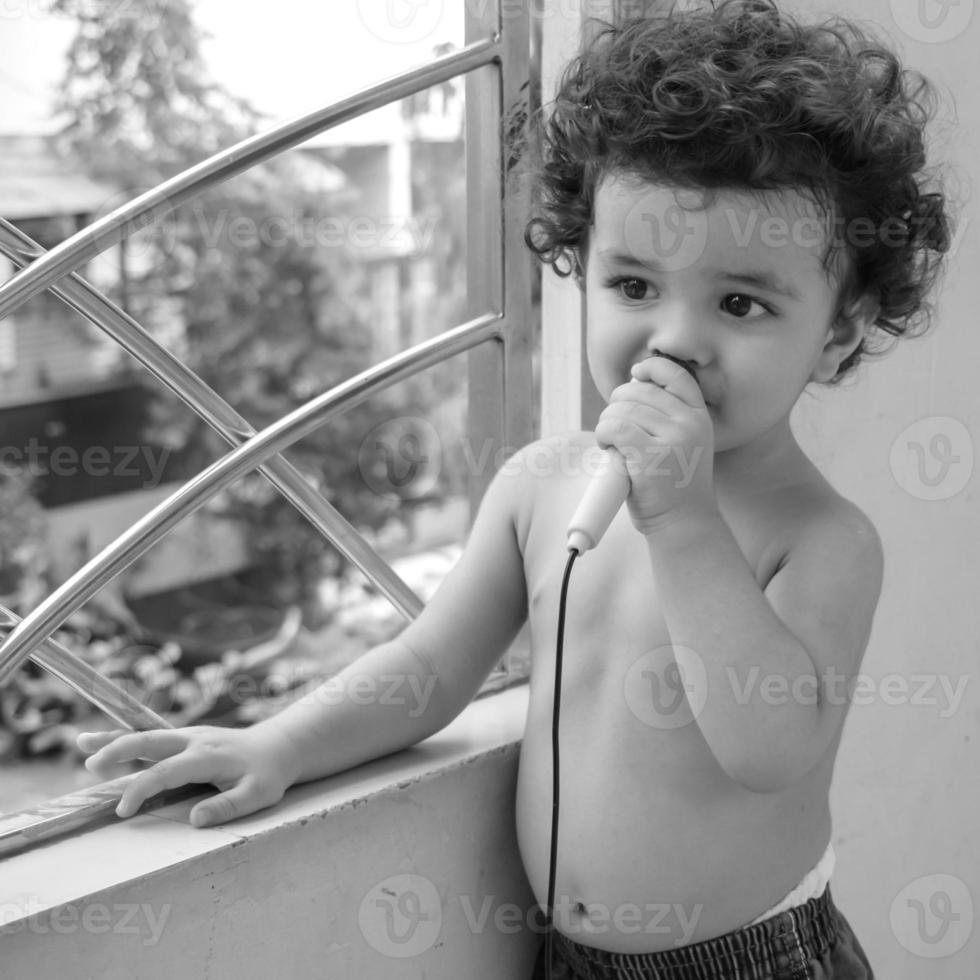 söt liten pojke shivaay sapra på Hem balkong under sommar tid, ljuv liten pojke fotografering under dag ljus, liten pojke njuter på Hem under Foto skjuta - svart och vit