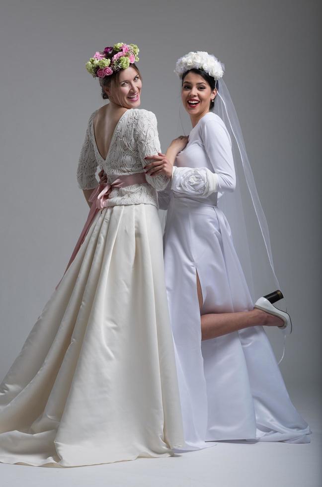 porträtt av två skön ung brud i bröllop klänningar foto