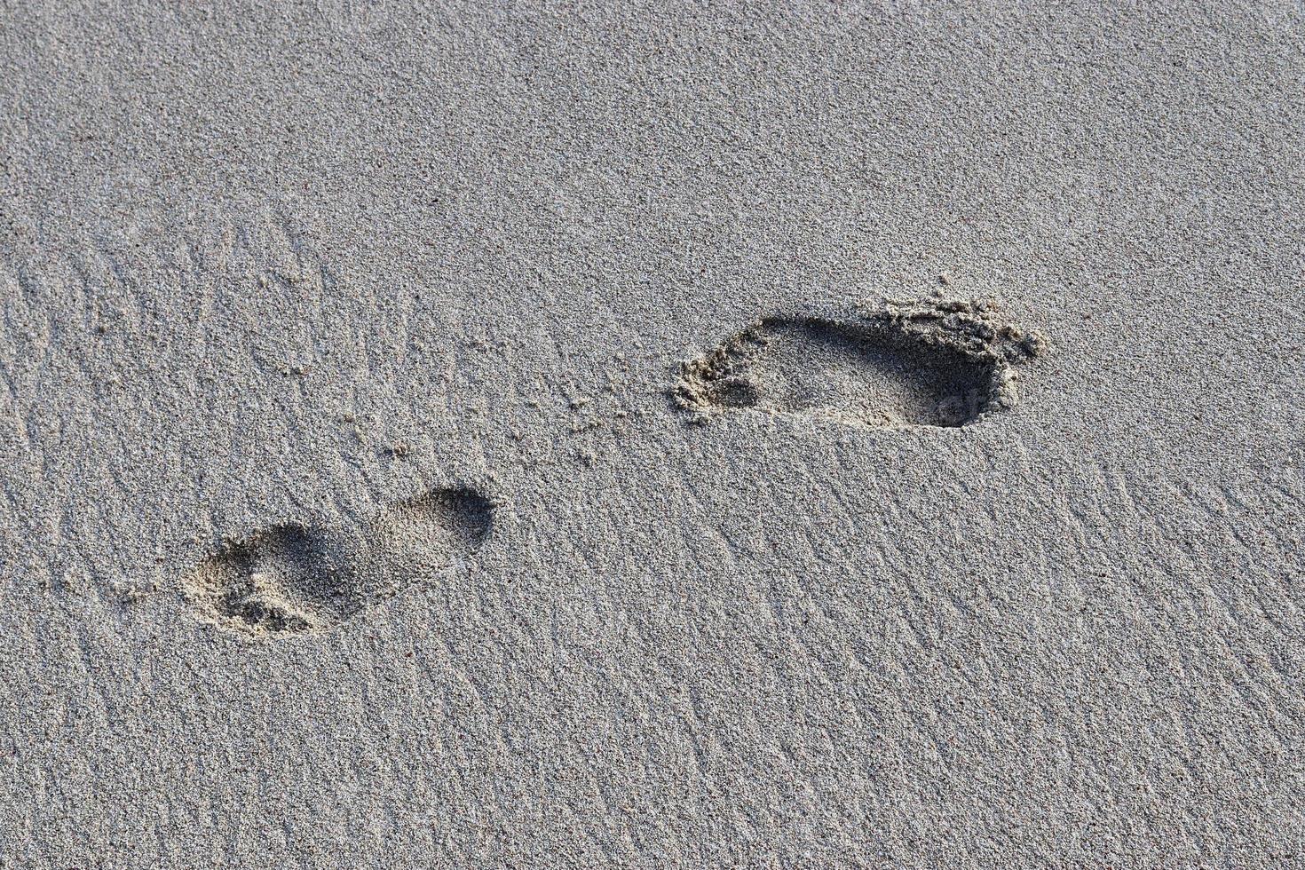 skön skott av de vit strand sand på de Seychellerna paradis ö med fotspår foto
