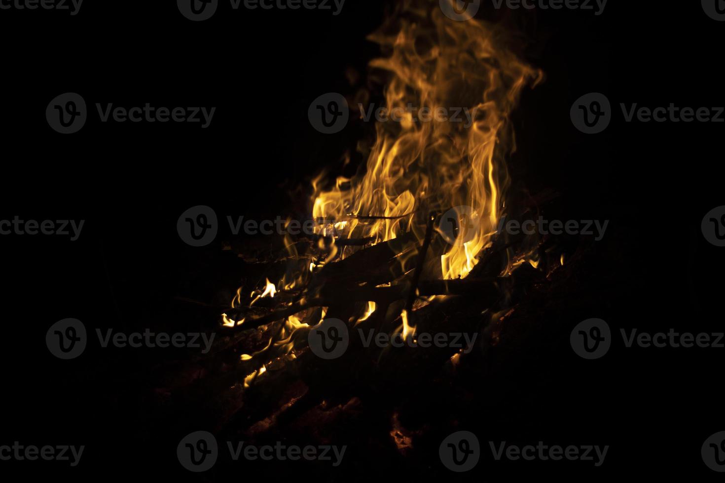 bål i mörk. brand på svart bakgrund. detaljer av flamma. foto