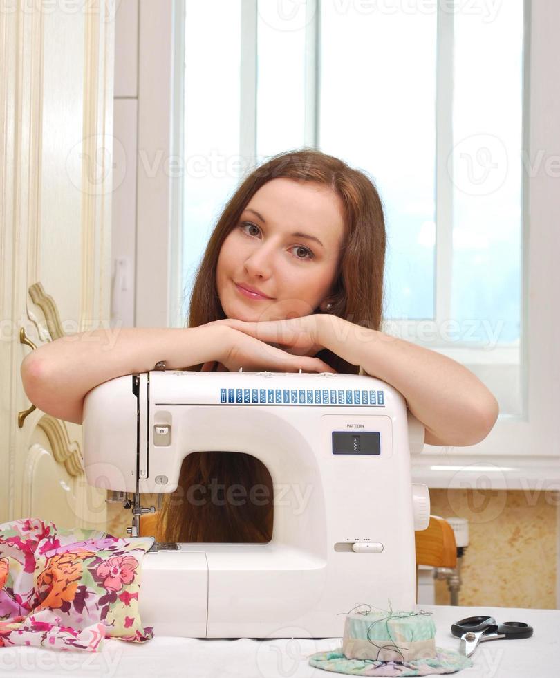 kvinnans sömmerska arbetar på symaskinen foto