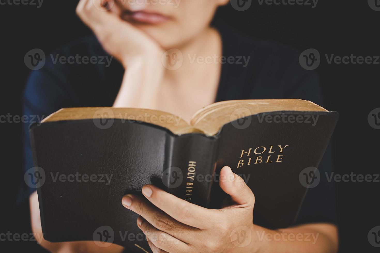 ung kvinna person hand innehav helig bibel med studie på Hem. vuxen kvinna kristen läsning bok i kyrka. flicka inlärning religion andlighet med be till Gud. begrepp av studerande utbildning tro. foto