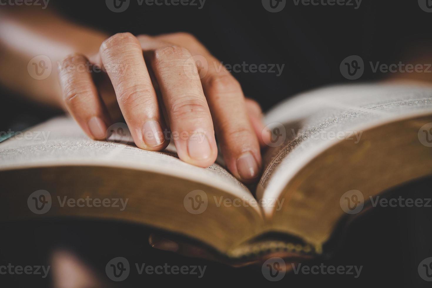 ung kvinna person hand innehav helig bibel med studie på Hem. vuxen kvinna kristen läsning bok i kyrka. flicka inlärning religion andlighet med be till Gud. begrepp av studerande utbildning tro. foto