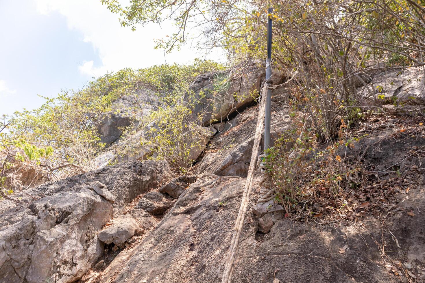 klippa väntar för människor till klättra upp med en rep till underlätta.med de himmel som de mål foto