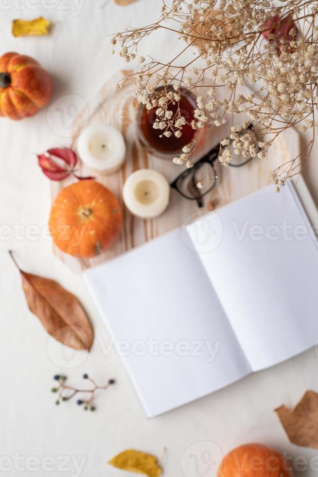 vit tom bok med höst löv och kopp av varm te på gammal tabell , attrapp design, fokus av förgrund foto