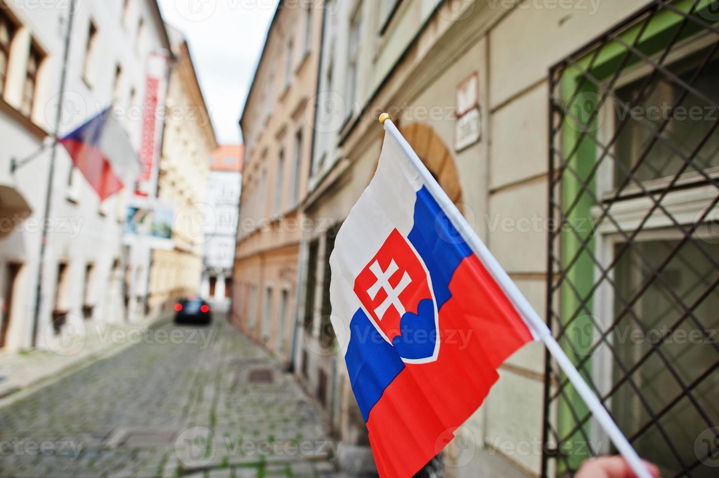 flagga av slovakia i hand mot gata av bratislava. foto