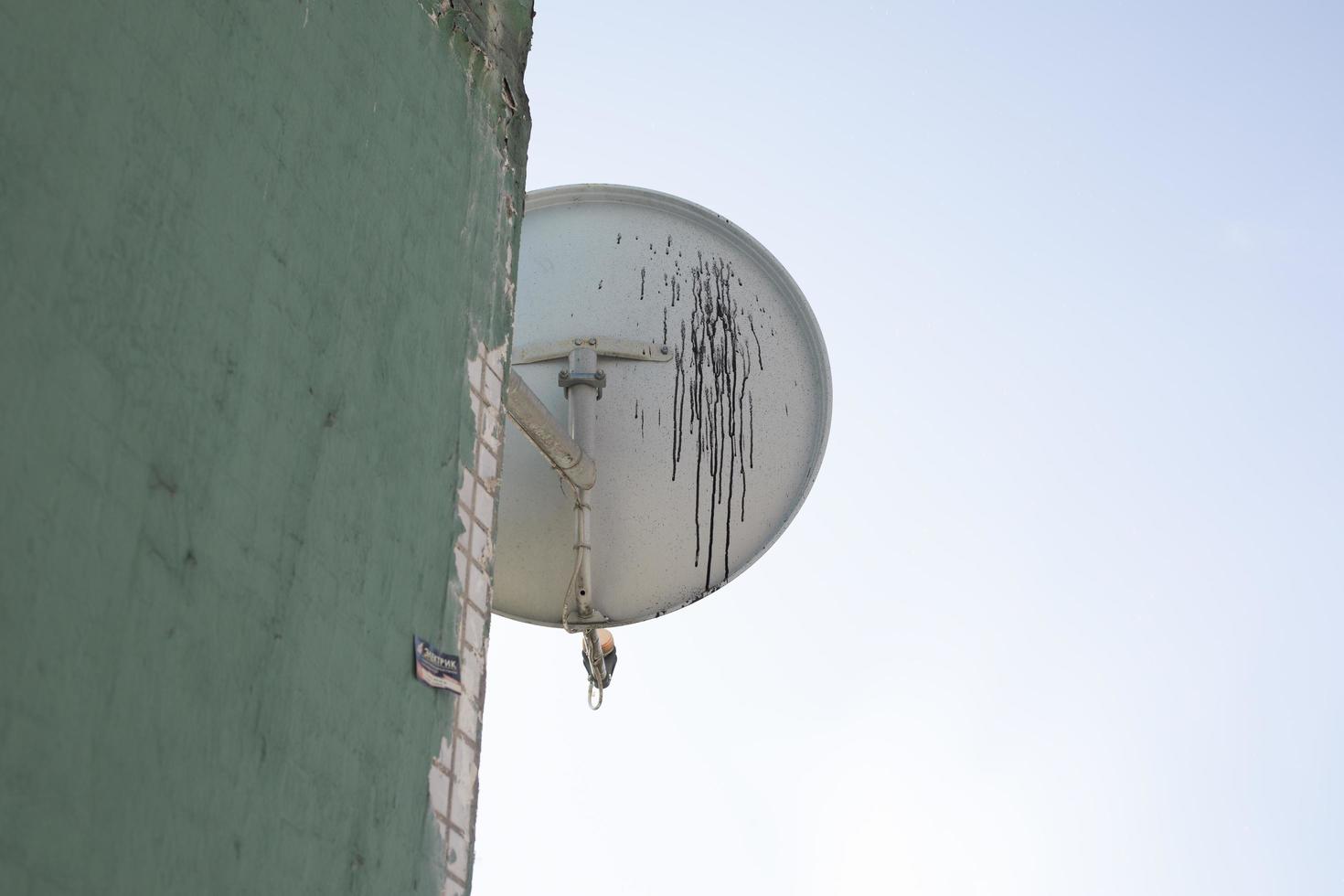 gammal satellit maträtt på hus. smuts på antenn skiva. notera TV signal. foto