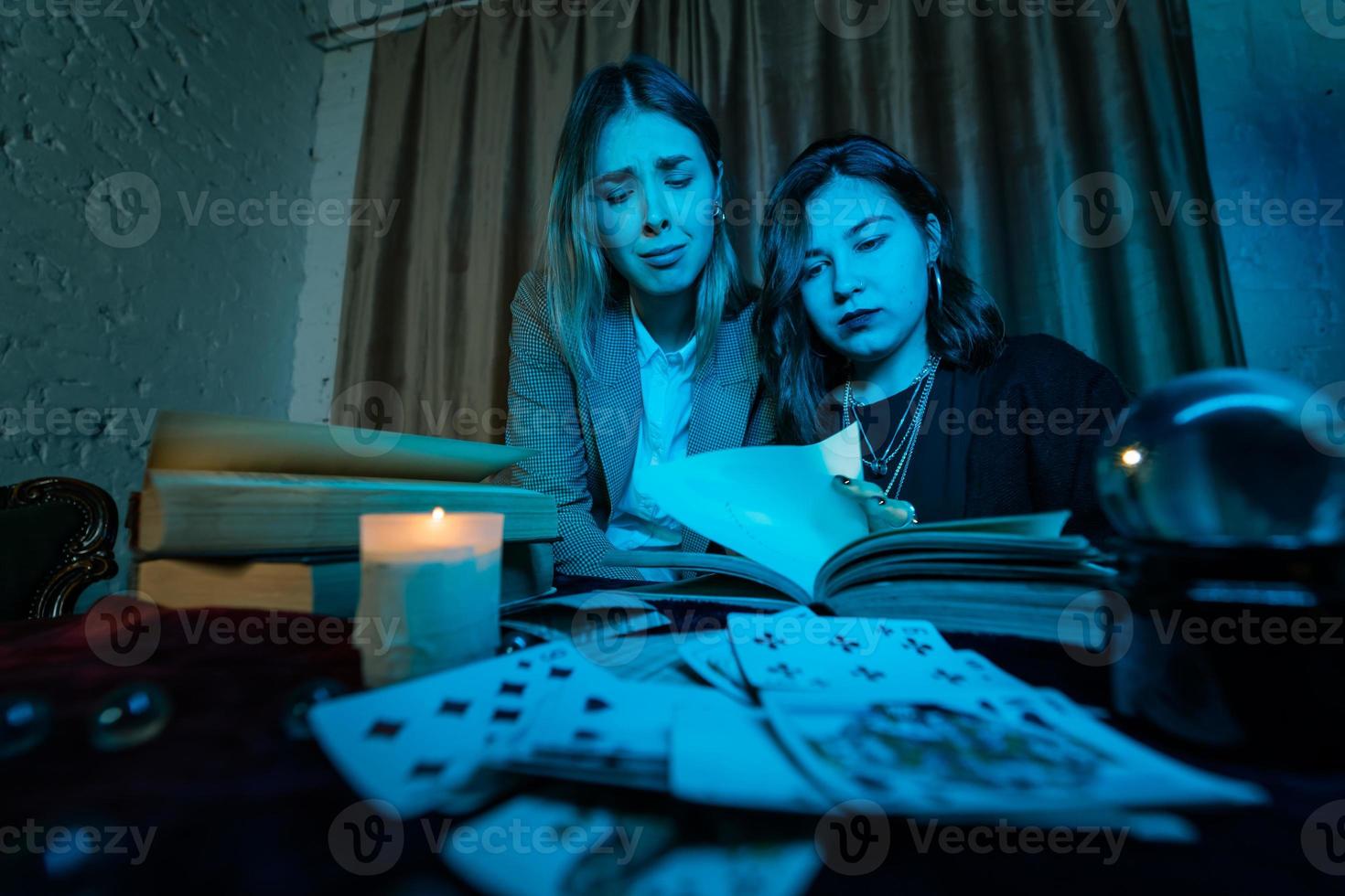 två kvinnor är läsning en mystisk bok foto