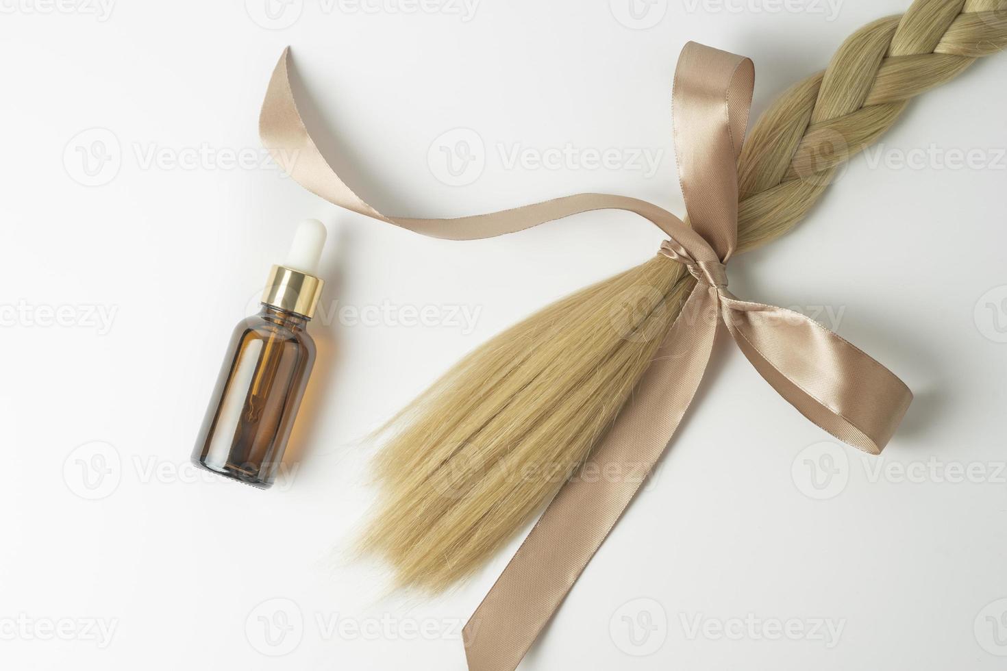 en naturlig olja eller serum för hår vård behandling liggande på en vit bakgrund foto
