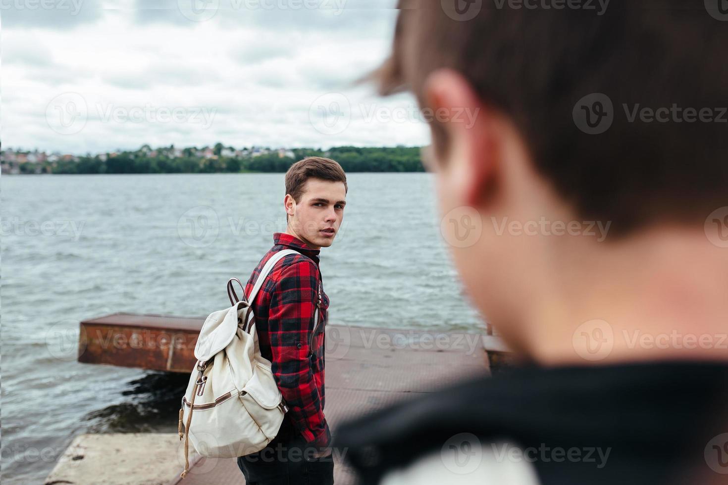 två unga killar som står på en pir foto