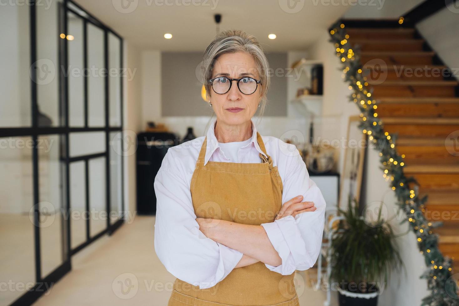 porträtt av sträng mormor stående i missnöjd utgör stirrande arg på kamera foto