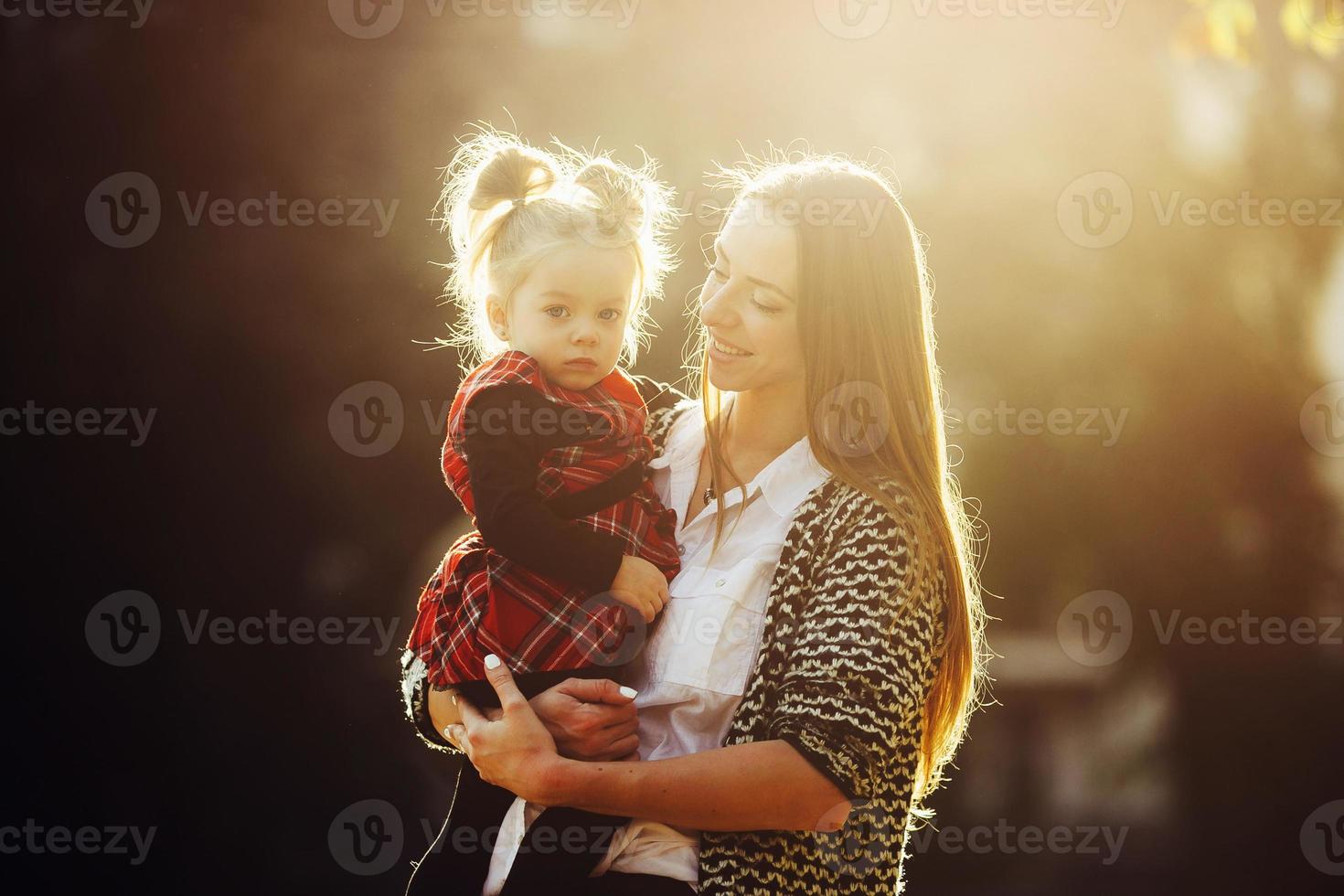 mor och liten dotter spelar i en parkera foto