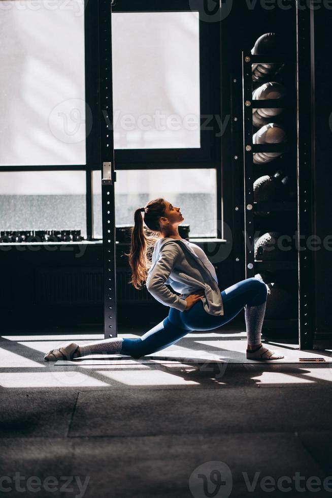 porträtt av attraktiv ung kvinna håller på med yoga eller pilates övning foto