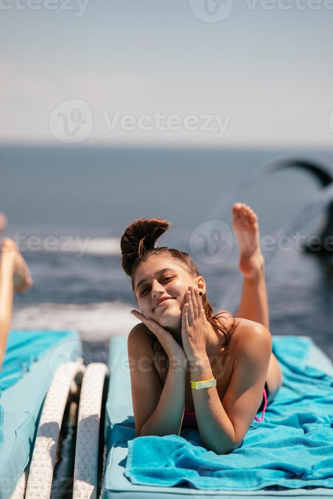 ung skön kvinna i baddräkt sola på en Sol vilstol foto
