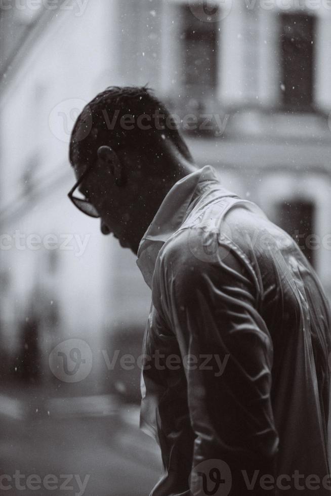 porträtt av sorglös stilig ung man är känsla fri under de regn foto