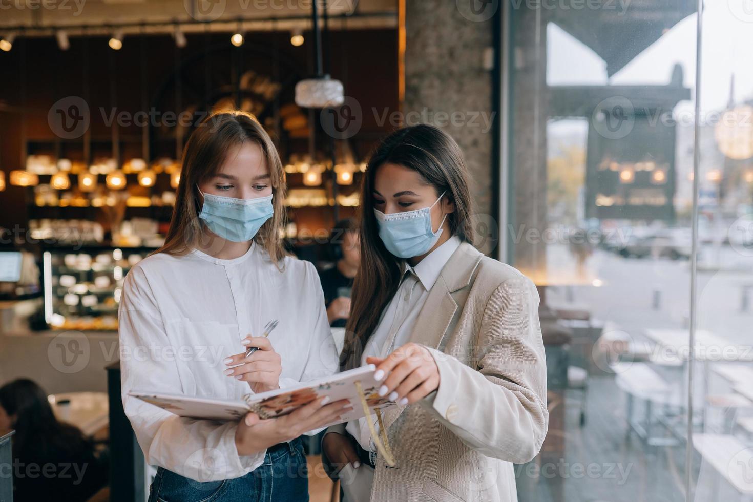 två affärskvinna med deras ansikte masker debatterande annorlunda visningar på arbete foto