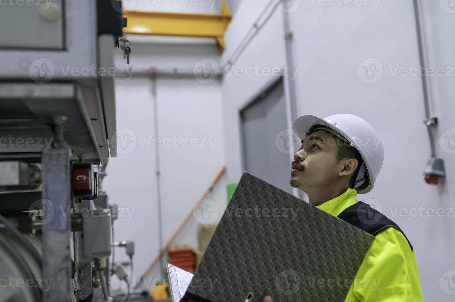 elektrisk ingenjör man kontroll Spänning på de kraft distribution skåp i de kontrollera rum, förebyggande underhåll årligen, thailand elektriker arbetssätt på företag foto