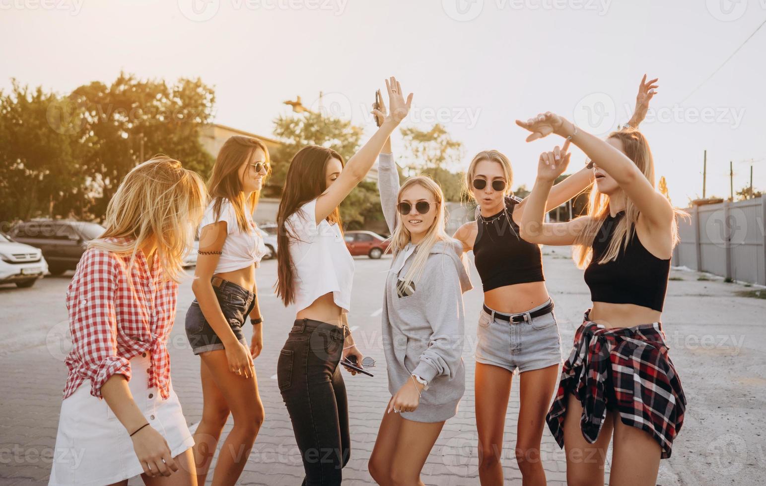 sex ung kvinnor dansa i en bil parkera foto