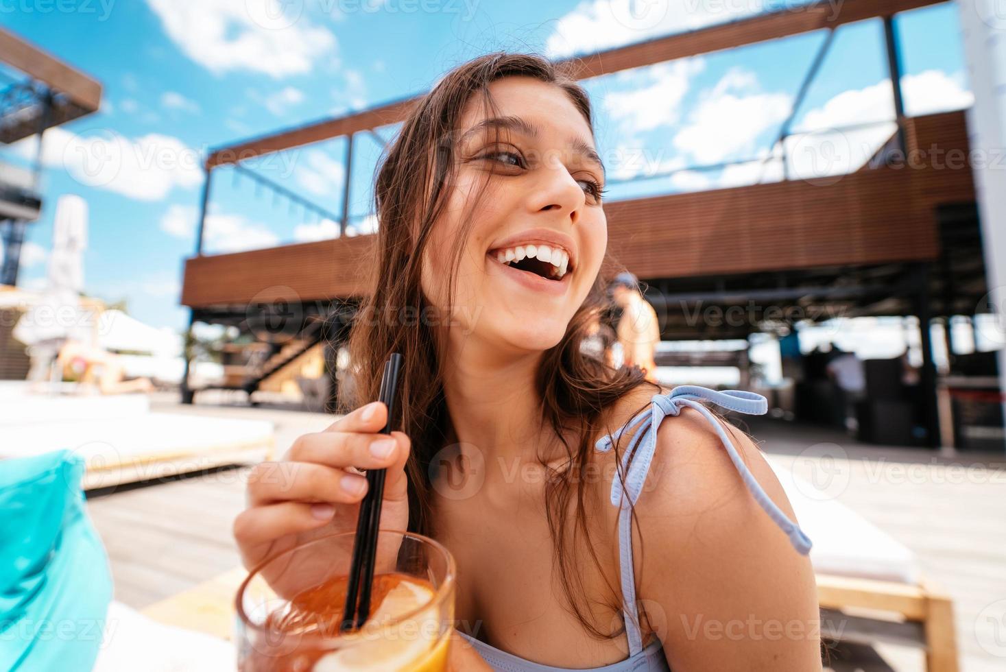 Söt kvinna i bikini dricka cocktail på slå samman fest. foto