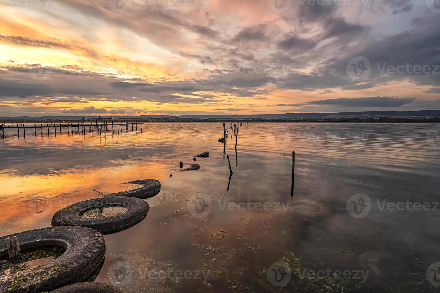 skön solnedgång på de sjö med fiske netto i vatten och gammal däck foto