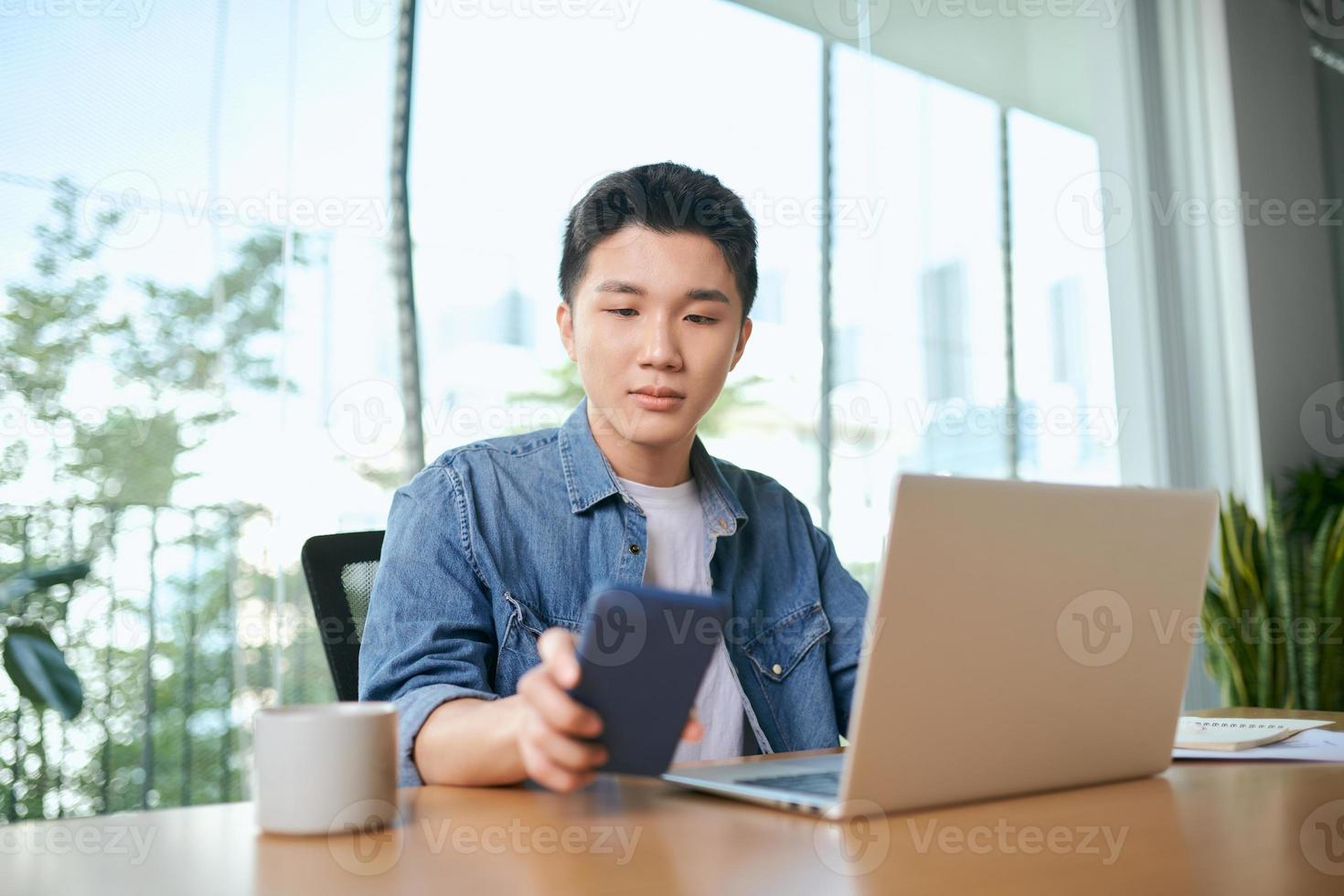 ung affärsman arbetssätt med mobil bärbar dator och dokument i kontor, företag begrepp foto
