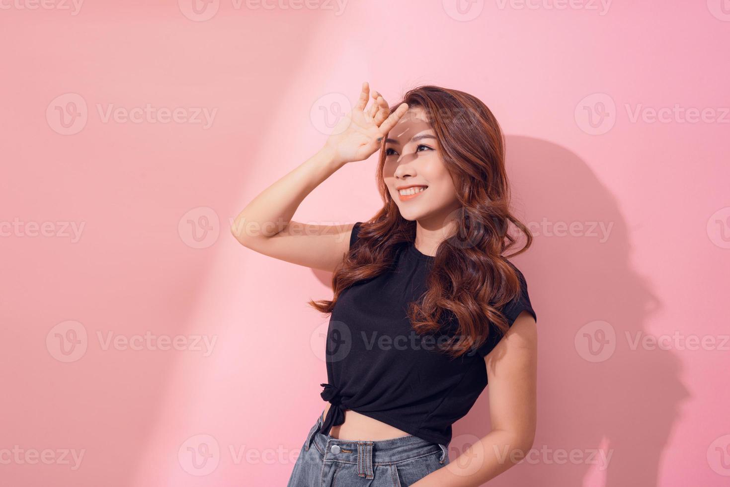 förtroende är ny sexig. porträtt av charmig lockigt hår kvinna i trendig plagg leende brett över rosa bakgrund. foto